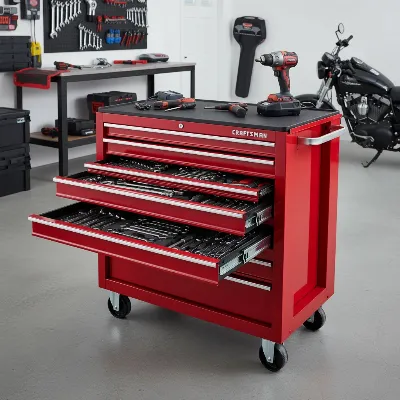 A Craftsman S2000 5-drawer red tool chest in a garage, showcasing its metal construction and smooth drawers, editorial style